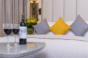 a bottle of wine and two glasses on a bed at Grand Hotel Tralee in Tralee
