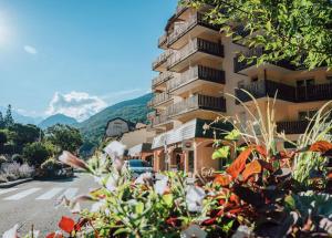 um edifício com um monte de plantas em frente dele em Résidence Eureca em Brides-les-Bains