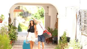 un hombre y una mujer de pie bajo un arco con equipaje en Balneario de Alicún de las Torres, en Villanueva de las Torres
