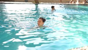 a woman is swimming in a swimming pool at Balneario de Alicún de las Torres in Villanueva de las Torres +43 photos