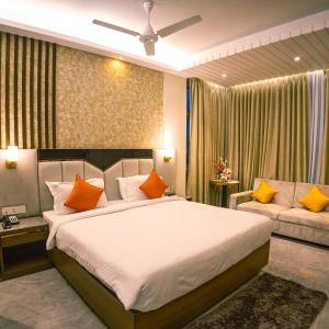 a bedroom with a large bed and a couch at Brio Hotel in Kolkata
