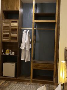 Dumani Nagar Hotel & Resort في هنزه: غرفة مع رف كتاب خشبي مع ملابس