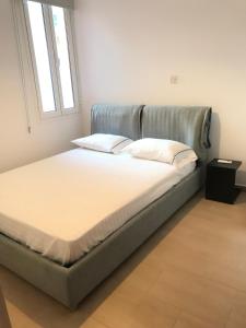 a bed with white sheets and pillows in a room at Villa Poseidon in Pervolia +10 photos