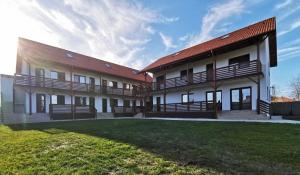 a building with a grass yard in front of it at Bobocel in Sfântu Gheorghe