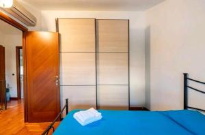 a bedroom with a blue bed and a closet at Casa Mary in Fregene