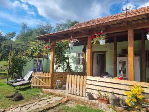 a small house with a porch and a bench at Casa cu levănțică in Balşa