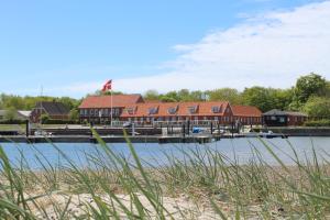 HvidbjergTambohus Kro & Badehotel的码头前临水而建的房子