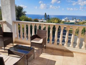 Un balcón con sillas y vistas al océano. en JOANNA SUNSET APTS Pomos, en Pomos