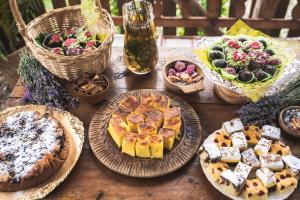a wooden table with pies and other food on it at Casa cu levănțică in Balşa +71 photos