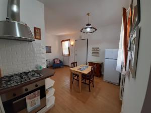 a kitchen with a stove and a table in a room at Casa di Lory in Sirolo
