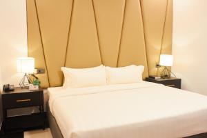 a bedroom with a large white bed with two lamps at The Blu Hotel in Baranghauon