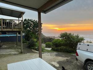 vistas al océano desde el porche de una casa en Linga Futhi Beach Cottages en Port St Johns