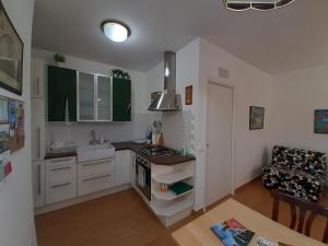 a kitchen with white cabinets and a sink and a stove at Casa di Lory in Sirolo