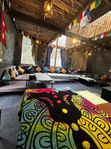 a room with couches and a colorful rug on the floor at Sunshine Cafe & Cottage Riverside in Shoja