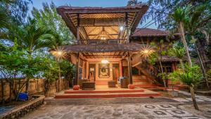 a house with a staircase leading to the front entrance at Alam Gili Trawangan by Mahaputra in Gili Trawangan