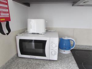 eine Mikrowelle auf einer Theke in der Unterkunft BCV - Private 1 Bedroomed Apartment Dunas Resort 3044 and 3077 in Santa Maria