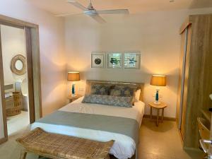 a bedroom with a bed with two lamps and two tables at Grand Baie - Très belle villa 3 chambres in Grand-Baie