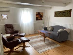 a living room with a couch and chairs and a table at Tofta stugan in Tofta