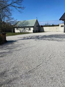 an empty driveway in front of a white house at Tofta stugan in Tofta