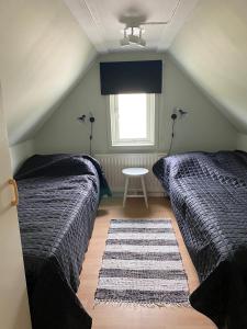 a bedroom with two beds and a table with a window at Tofta stugan in Tofta