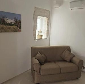 - un salon avec un canapé et un miroir dans l'établissement Casa Garibaldi 246 Ostuni centro storico, à Ostuni