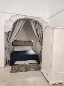 - une chambre avec un lit à baldaquin dans l'établissement Casa Garibaldi 246 Ostuni centro storico, à Ostuni