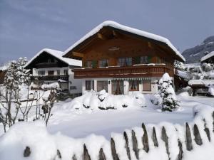 a house covered in snow with a fence at Landhaus Bergkristall - Sommer Bergbahnen inklusive in Oberstdorf