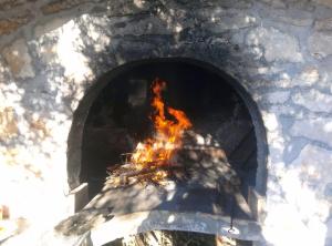 a brick oven with a fire in it at Apartments and Rooms Saric in Jadrija