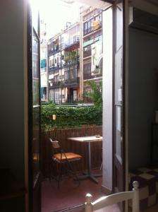 un balcón con mesa y silla y un edificio en SANT ANTONI HOSTAL, Sustainable Tourism, en Barcelona