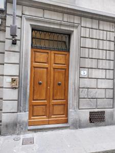 une porte en bois sur le côté du bâtiment dans l'établissement Florenceunita, à Florence