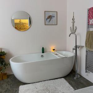 eine weiße Badewanne im Bad mit Spiegel in der Unterkunft Skipper’s Cottage - Perfect for Cardiff & Penarth in Cardiff + 8 Fotos