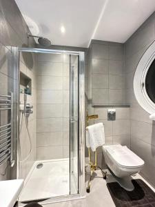 a bathroom with a shower and a toilet and a sink at Stylish Central London Apartment in London