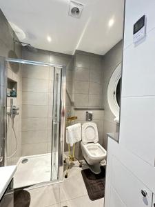 a bathroom with a toilet and a shower and a sink at Stylish Central London Apartment in London