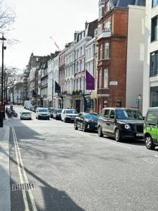 una concurrida calle de la ciudad con coches aparcados en la carretera en Stylish Central London Apartment, en Londres