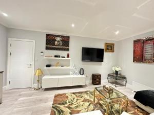 a living room with a couch and a tv on the wall at Stylish Central London Apartment in London