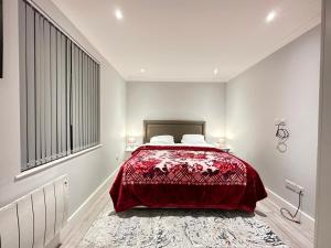 a bedroom with a bed with a red bedspread at Stylish Central London Apartment in London
