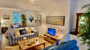 ein Wohnzimmer mit Sofa und Tisch in der Unterkunft Skipper’s Cottage - Perfect for Cardiff & Penarth in Cardiff