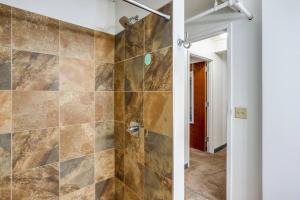a bathroom with a walk in shower next to a door at Centric Modern Loft w/ King Beds in Rochester