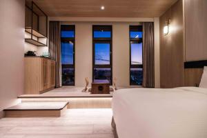 a bedroom with a bed and windows with a view at Euphoria Hotel Lukang in Lukang