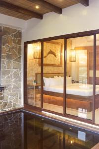 1 dormitorio con una gran ventana de cristal y 1 cama en The Blu Hotel, en Baranghauon