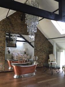 ein Esszimmer mit einem Kronleuchter und einem Tisch in der Unterkunft Chez Thomas 7 Route du Monde Ancien in Saint-Georges-dʼAunay