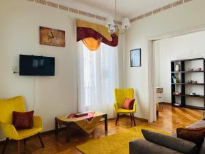 a living room with yellow chairs and a table at Sea voyage in Nafplio