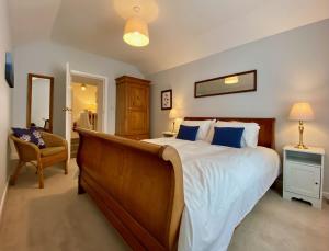 a bedroom with a large bed and a chair at Skipper’s Cottage - Perfect for Cardiff & Penarth in Cardiff