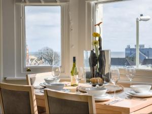 une table à manger avec des verres et un vase dans l'établissement Sunrise View, à Seaton