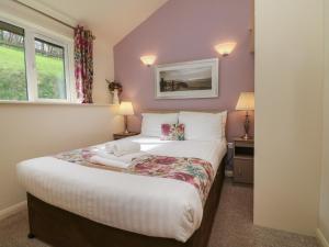 1 dormitorio con 1 cama grande en una habitación en Chalet Log Cabin L12, en Ilfracombe