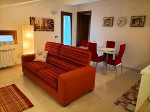 a living room with a red couch and a table at Come a casa in LʼAquila