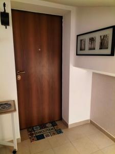 拉奎拉的住宿－Come a casa，一间铺有瓷砖地板的客房内的棕色门