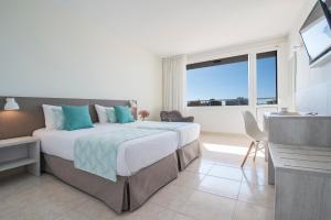 ein Schlafzimmer mit einem großen Bett und einem großen Fenster in der Unterkunft Hotel Lloret Santa Rosa by Pierre & Vacances in Lloret de Mar