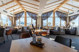 un ristorante con tavoli, sedie e finestre di Hotel Obereggen a Obereggen