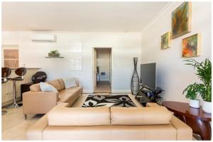 a living room with a couch and a table at Charming, Cosy, Classic Executive 1 Bedroom Apartment in Perth